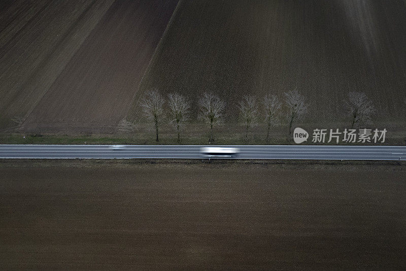 穿过田野的道路-动态模糊的汽车-鸟瞰图