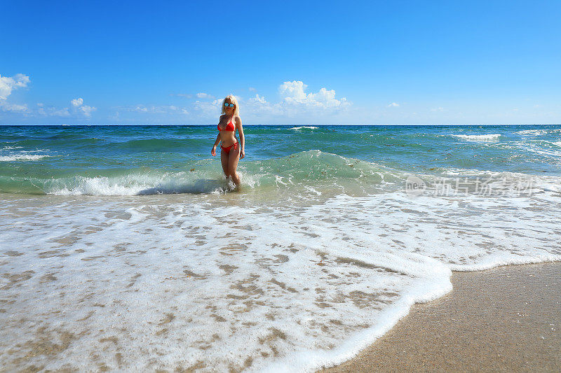 成熟美丽的金发女子在比基尼享受热带海滩度假
