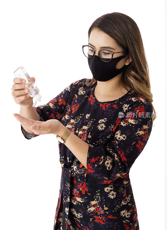 年轻女子戴着口罩手持抗菌凝胶