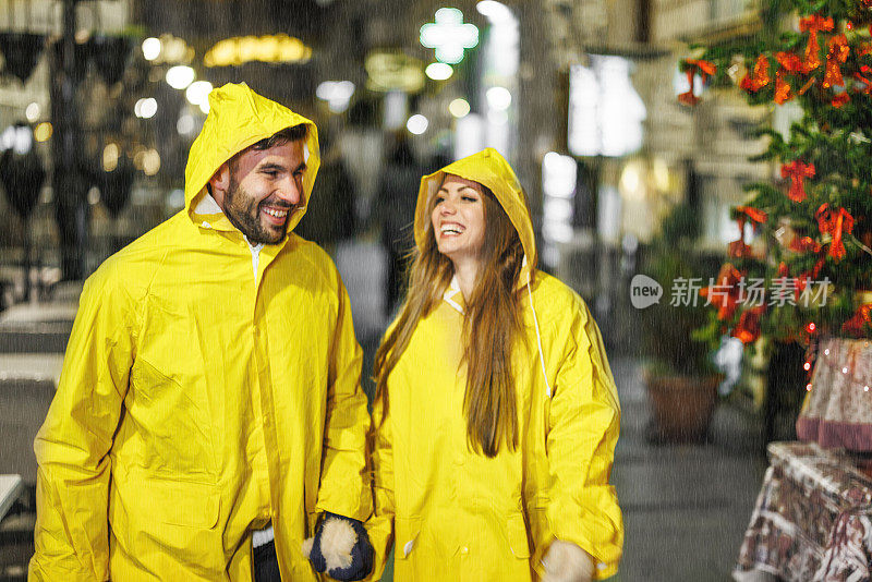 一对年轻夫妇在雨夜走在街上。