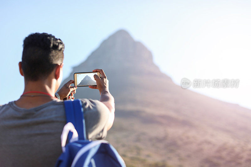 一名年轻男子在南非开普敦的信号山上徒步旅行。