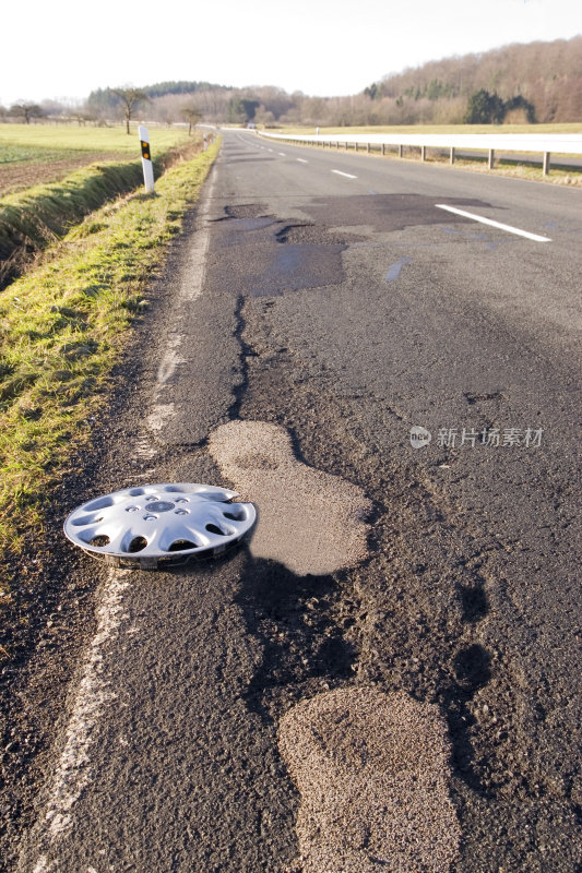 轮毂盖在损坏的道路上