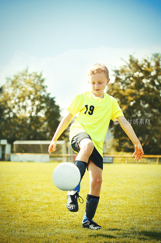 小男孩用球训练足球