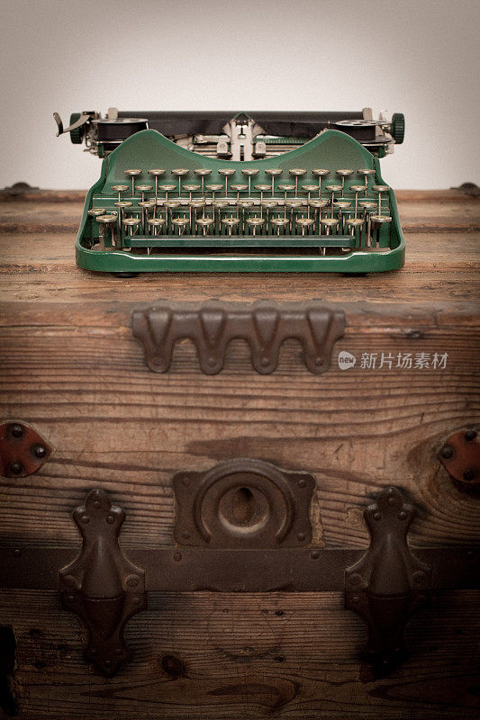 绿色的彩色图像，老式手动打字机，在木头树干上
