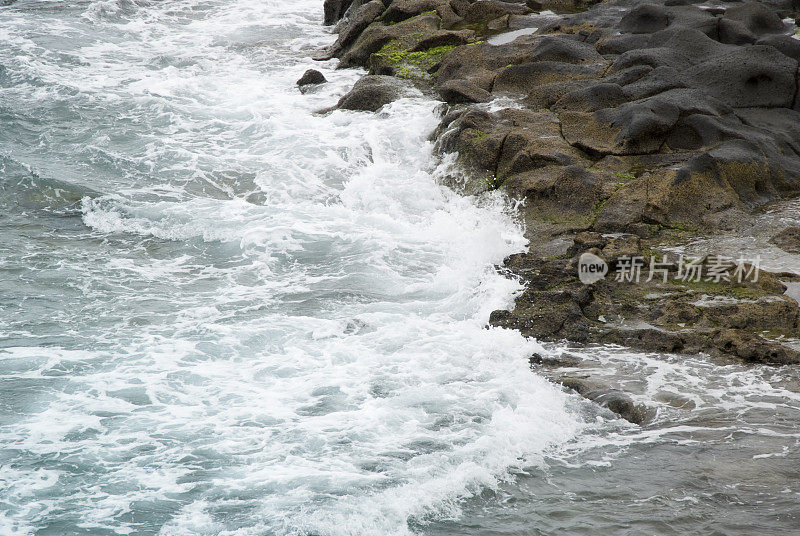 汹涌的大海，海浪拍打着布满岩石的海岸线