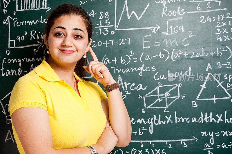 年轻开朗有魅力的印度女教师在教室与Greenboard