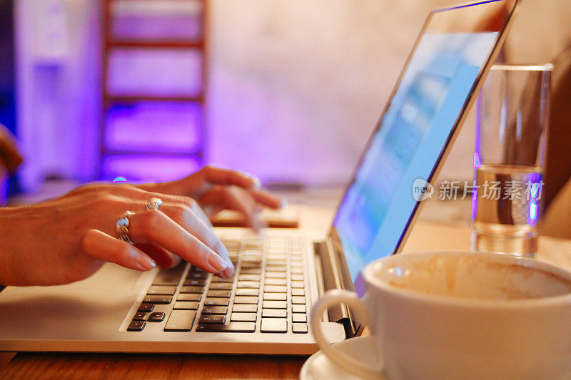 自由女设计师在咖啡馆里拿着笔记本电脑