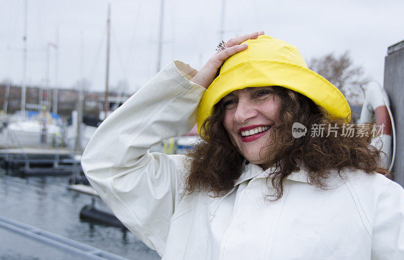 在码头上，一个女人在刮风的天气里大笑