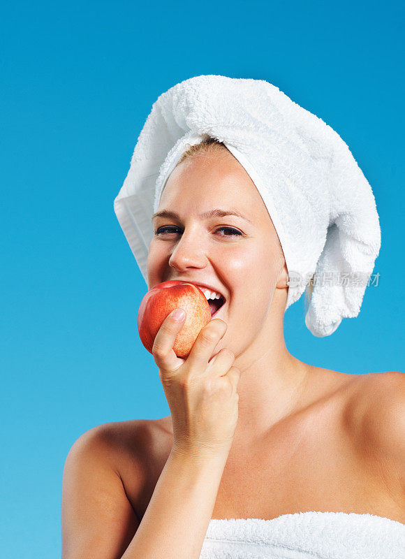 裹着毛巾吃苹果的女人