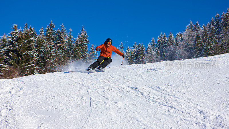 男性滑雪者出现在坡顶滑雪速度