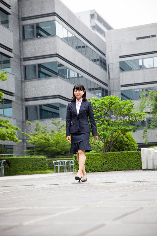 成功的亚洲商业女性走路