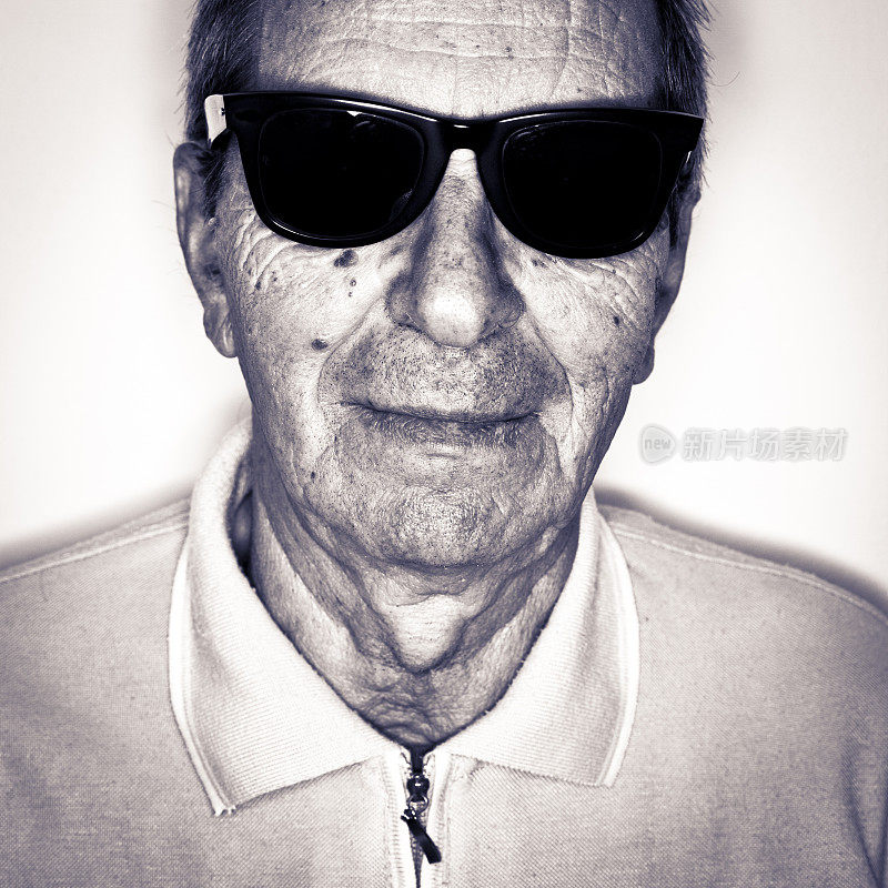 老男人戴着黑色太阳镜看着相机肖像