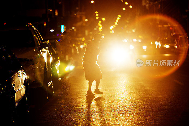 人们在晚上穿过繁忙的马路