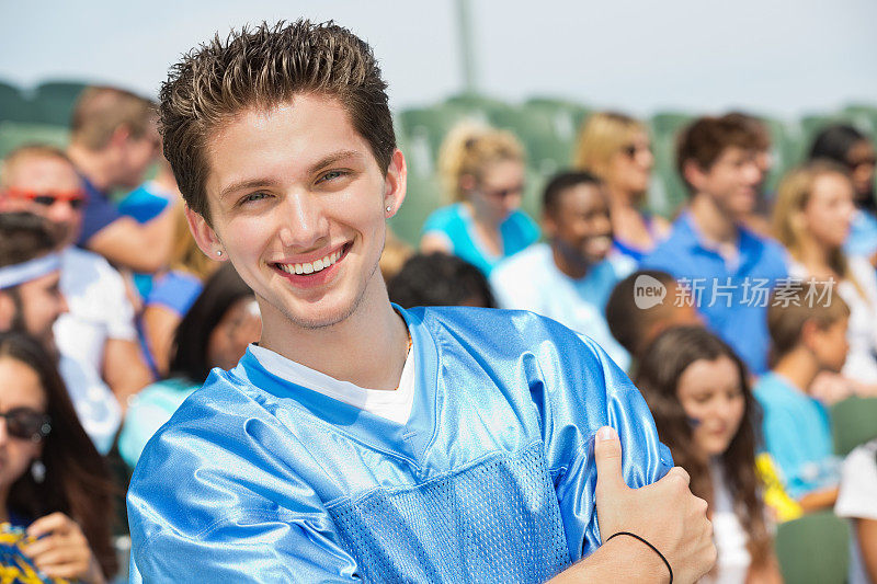 青少年体育迷在拥挤的体育场体育赛事中微笑