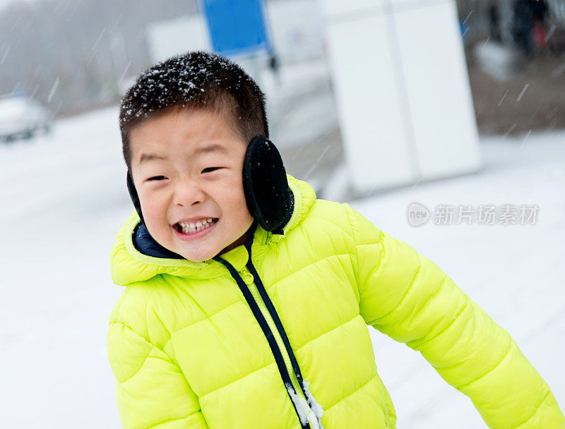 一个亚洲男孩在雪地里玩