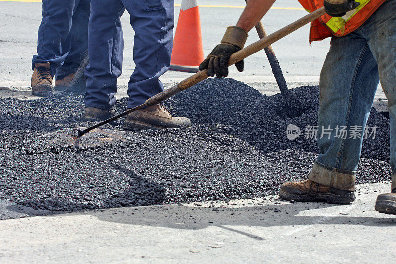 在公路维修现场铲和耙热沥青