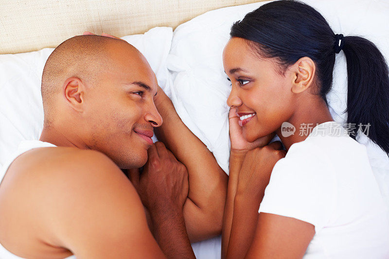 一对幸福的夫妇在床上看着对方
