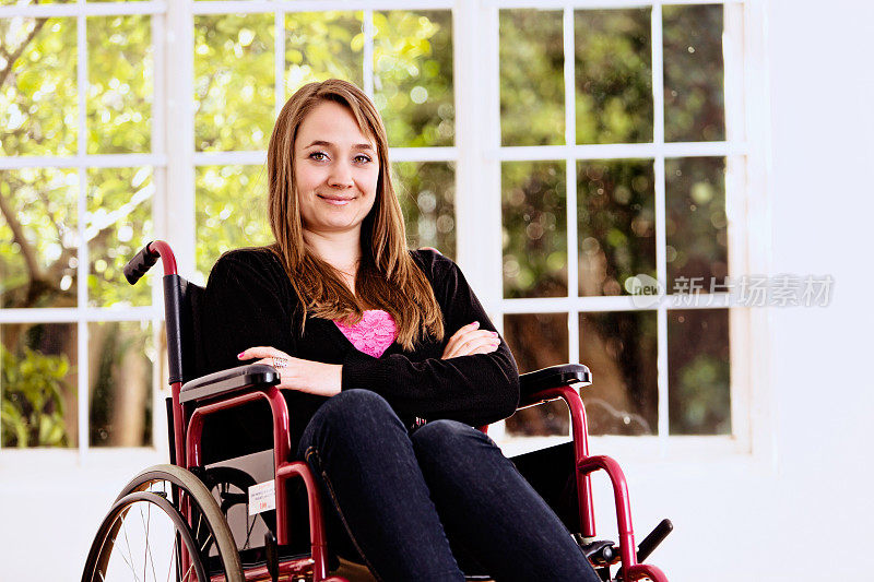 被限制在轮椅上的美丽年轻女子勇敢地微笑