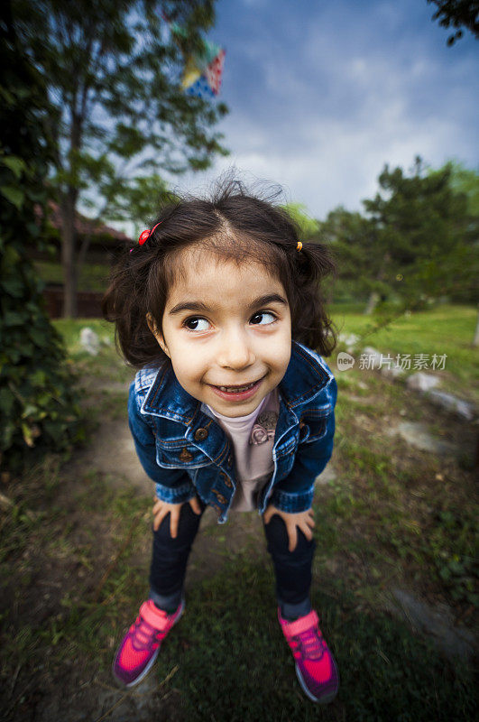 广角近距离拍摄的高加索幼童女孩在外面做鬼脸