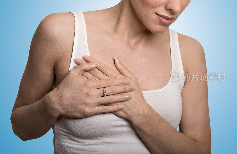 特写裁剪的肖像年轻女性与乳房疼痛触摸胸部颜色孤立在蓝色的背景