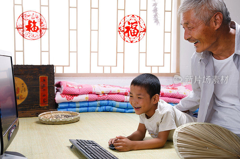 农民祖孙两人坐在床上看电脑
