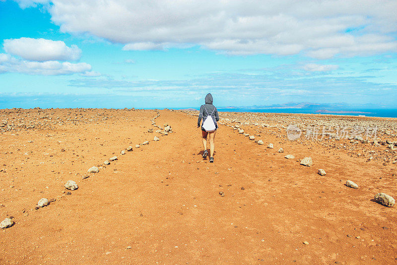 年轻女子徒步旅行与全景火山