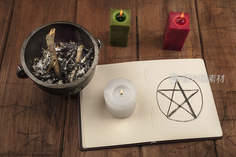 一张蜡烛的照片，一个女巫的坩埚，还有一本阴影书里的五角星