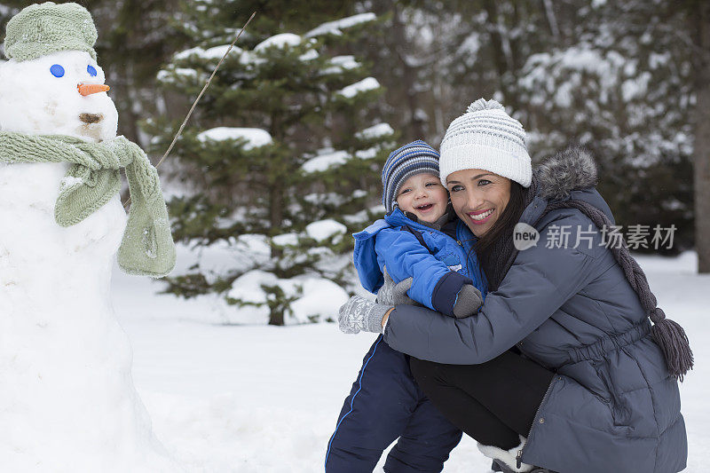 爸爸和妈妈带着他们的孩子，在雪里玩。