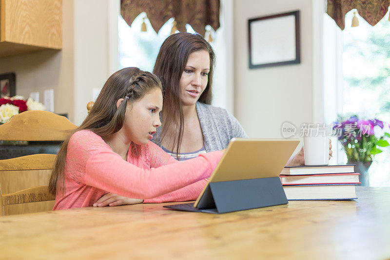 妈妈在餐桌上帮助女儿做家庭作业