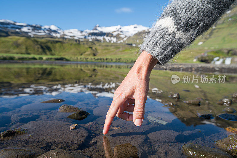 手指触摸冰岛的山湖表面