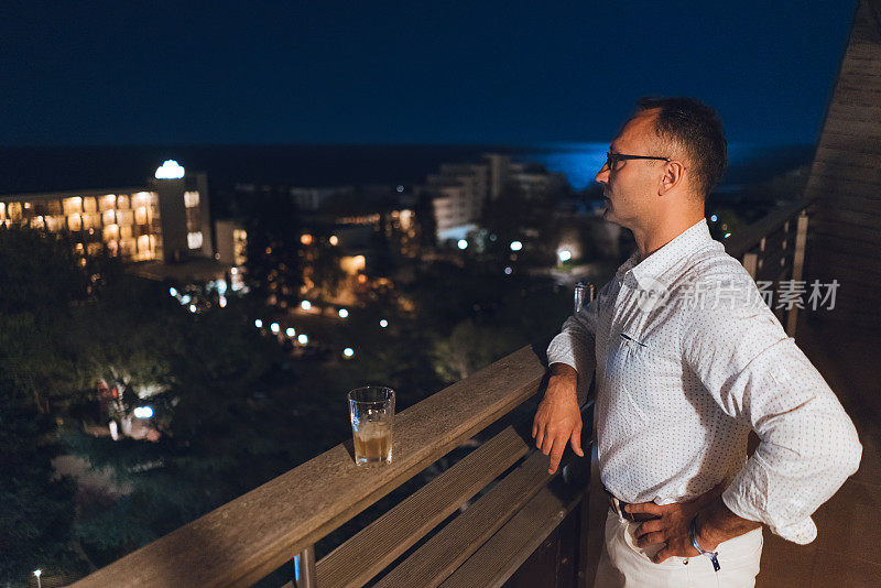 一个男人在酒店的阳台上欣赏风景
