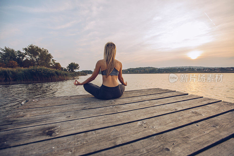 一个在湖边练习瑜伽的女人
