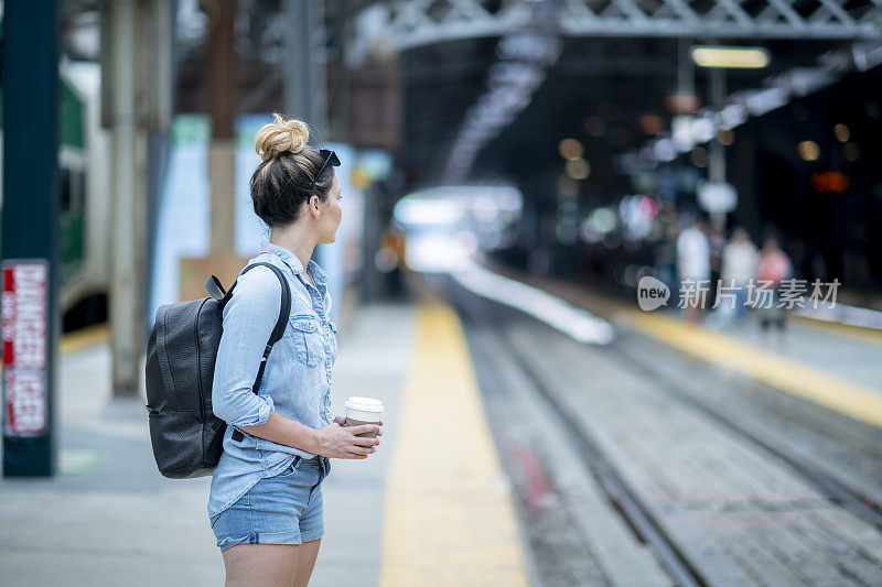 一个年轻的白人女人在站台上等火车