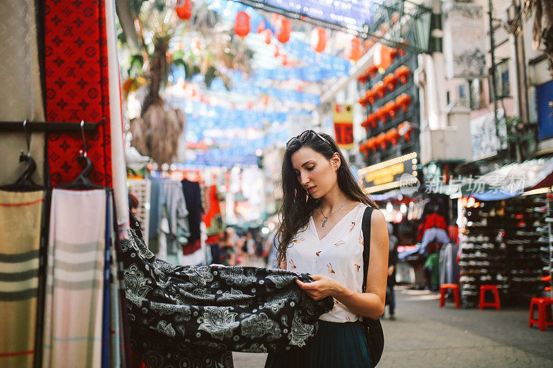 年轻的旅行者女人在吉隆坡唐人街区购物