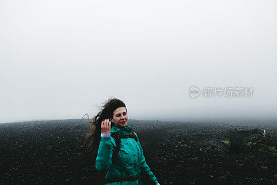 女人背包徒步旅行，虽然火山景观和风在冰岛无处