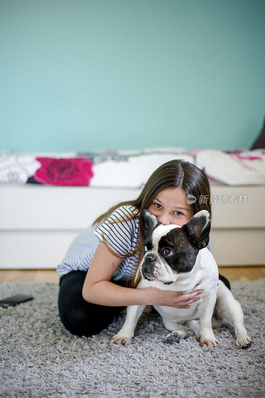 微笑的女孩和小法国斗牛犬在家