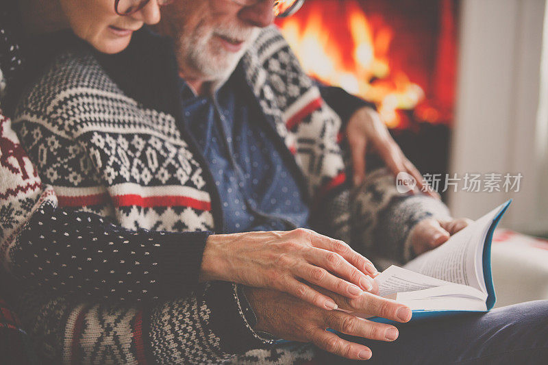 一对老年夫妇在壁炉边看书
