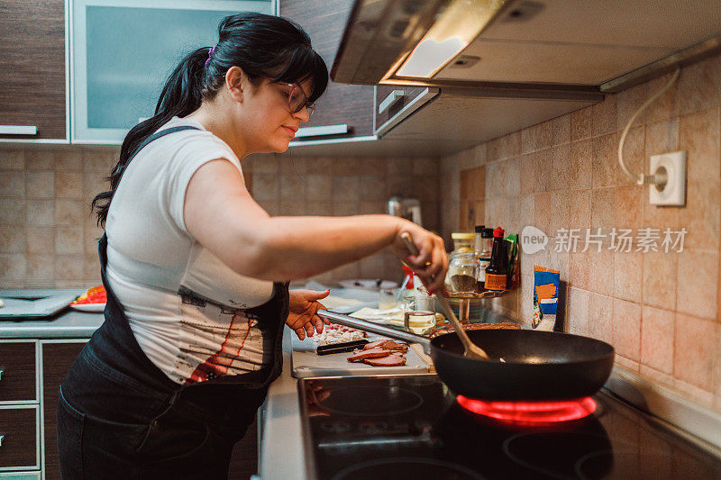 一个女人在厨房的平底锅里准备食物