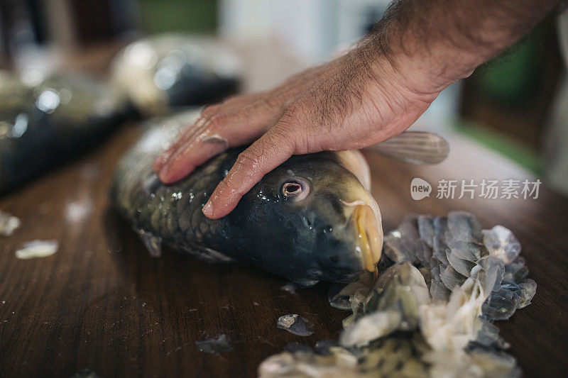 男子在家里的厨房里准备鲤鱼河鱼烹饪健康饮食食品