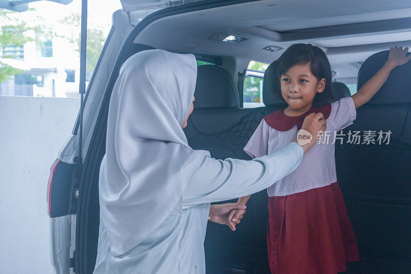亚洲穆斯林年轻母亲让女儿准备离家上学