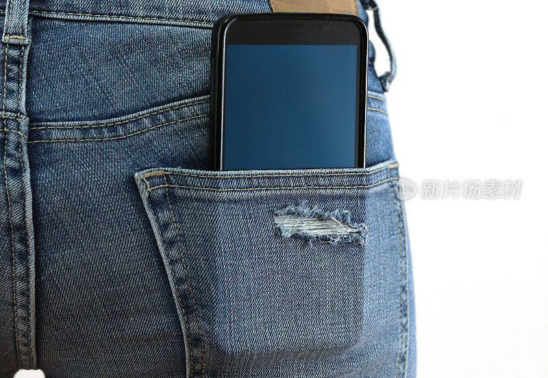 手机在一个女人的牛仔裤后口袋，在白色背景