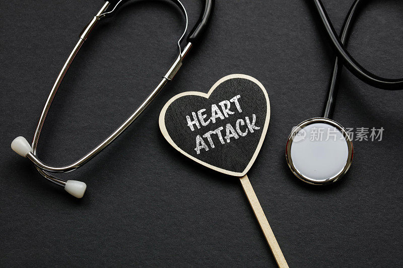 听诊器和文本在黑色背景心脏病发作