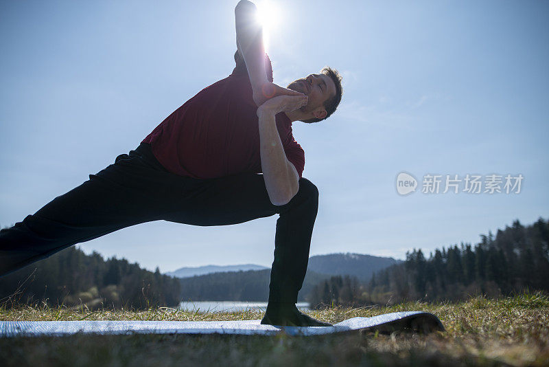 在一个阳光明媚的日子里，年轻人在大自然中伸展和做瑜伽练习