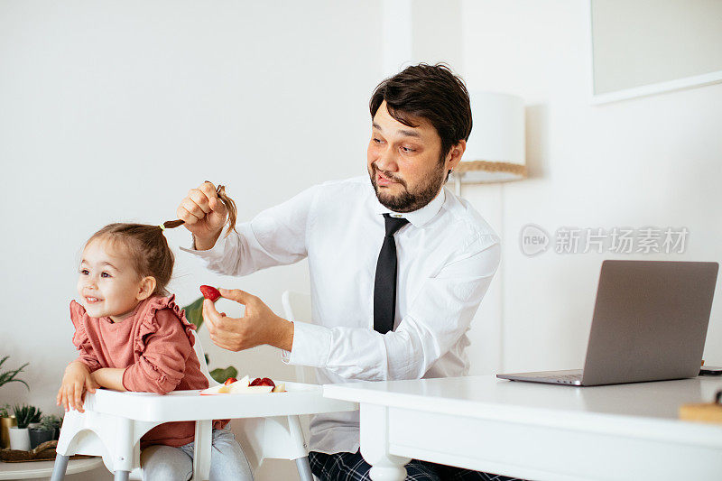 爸爸在家工作的时候给女儿喂奶