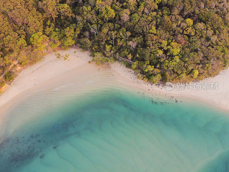 鸟瞰图美丽的绿松石海洋，海滩和树木森林散步，俯视图从无人机