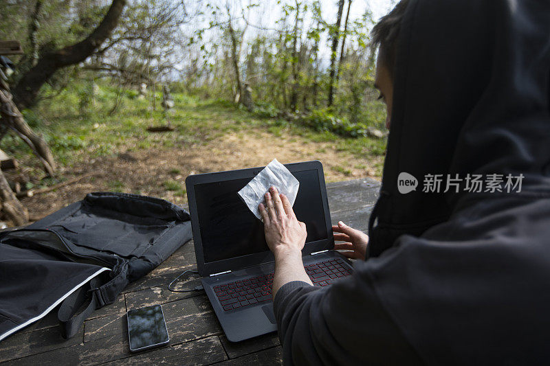 在农村场景的年轻的成年男子湿擦笔记本显示器的肩视图