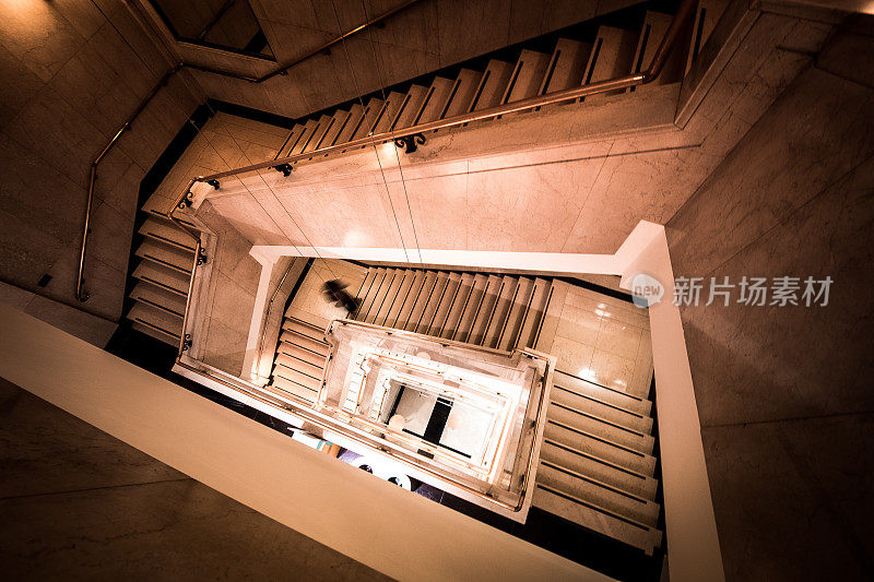 模糊运动的城市人跑下未来的现代螺旋楼梯