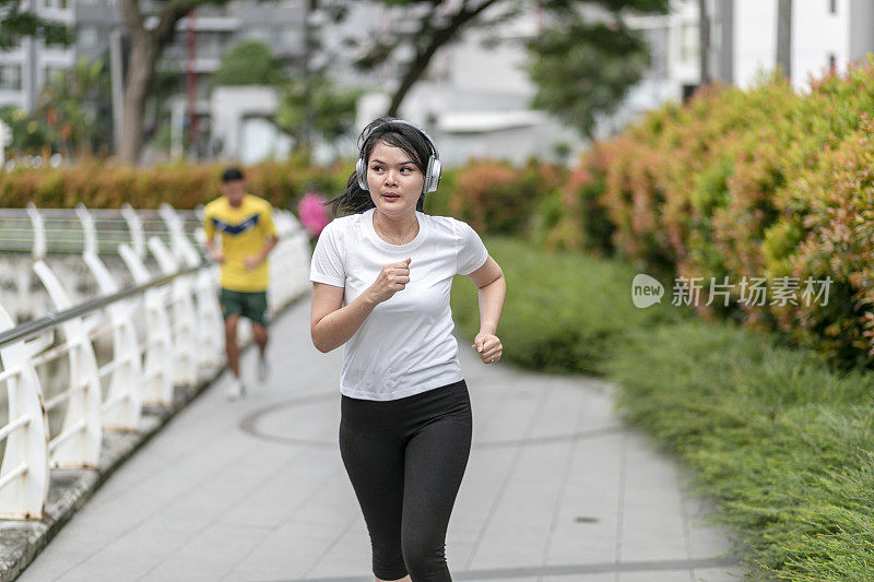 一个年轻女子在公园里跑步和锻炼