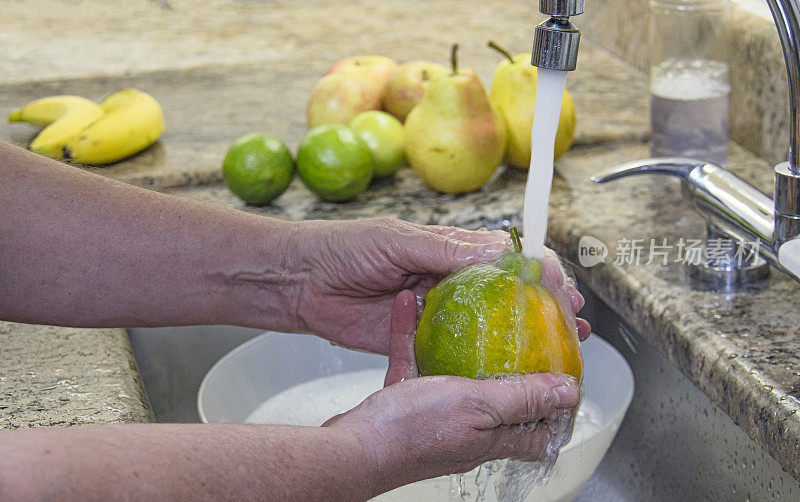 特写手，洗水果在家庭厨房水槽