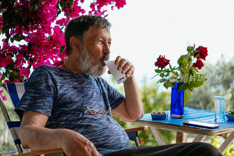 一个老人在喝土耳其拉基茴香酒